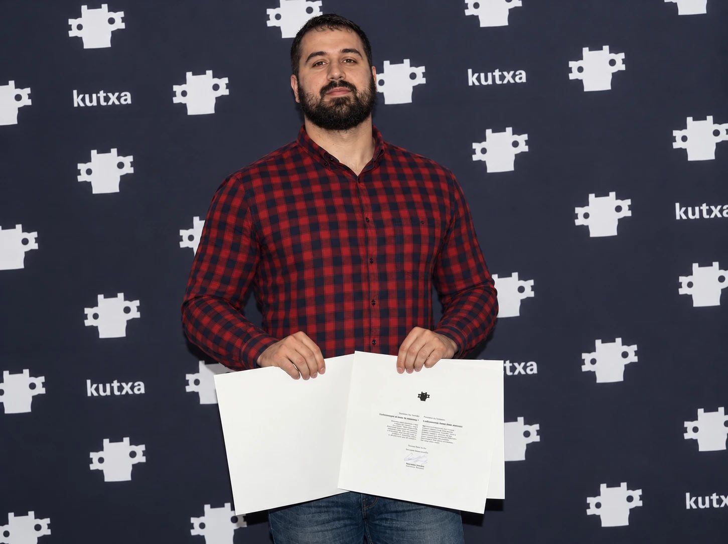 Alex Robleno at the Kutxa awards photocall, holding the Kutxa Final Studies Award, 2018